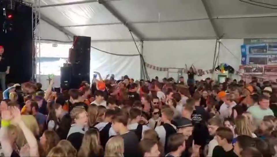 Zanger Mark Schokker in een volle feesttent, met duizenden mensen voor het podium